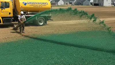 Hydroseeder truck spraying green slurry for new lawn installation in Harrisburg, PA landscaping project